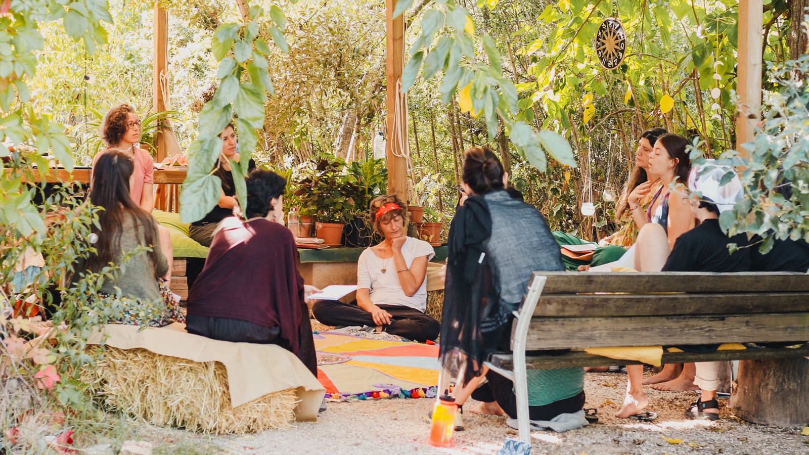 Participants compartint una trobada sota els arbres, al voltant del mandala